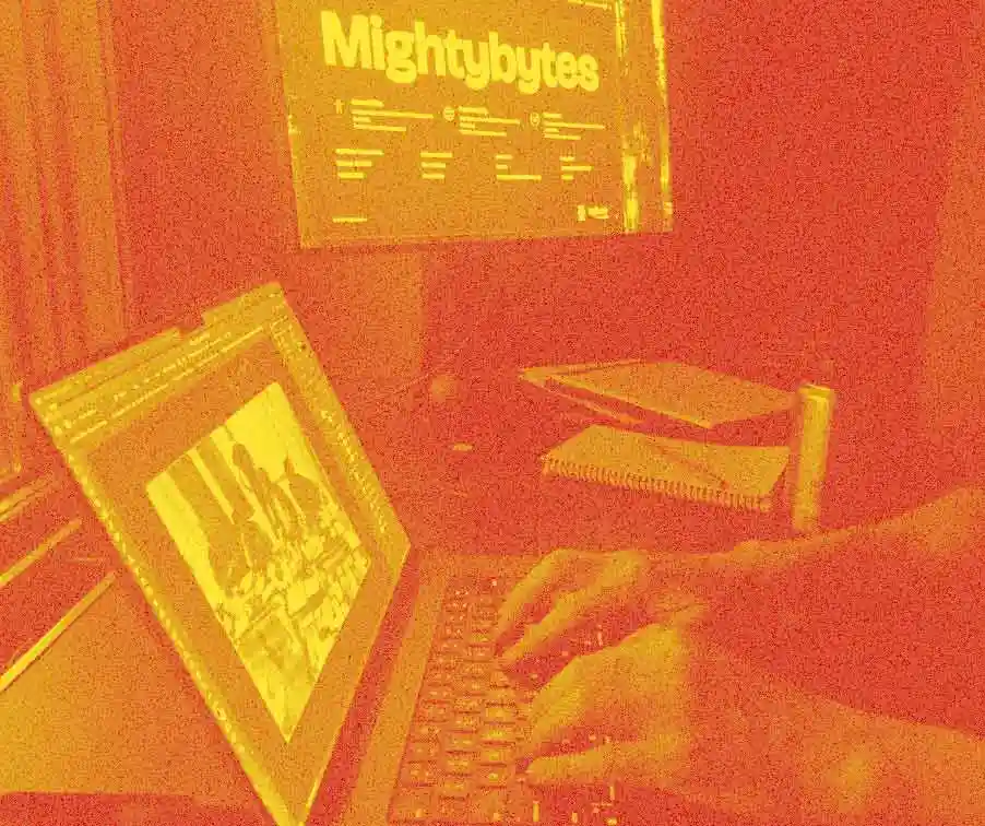 image of hands typing at a keyboard with the word Mightybytes on a second monitor in the background.